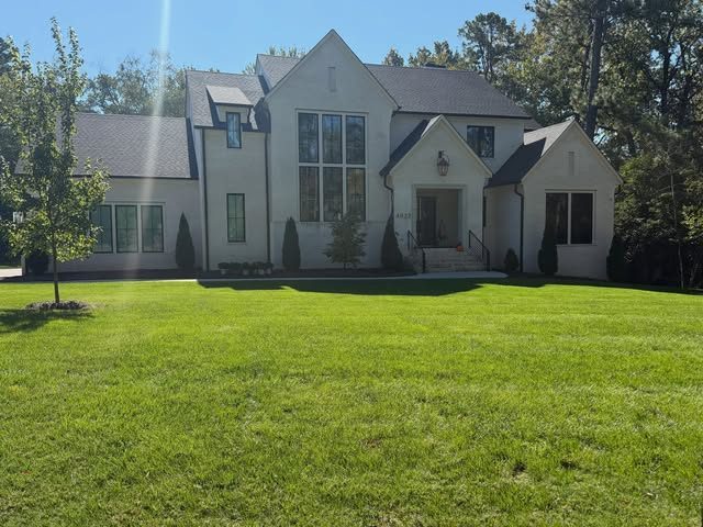 Thick green front lawn at a white brick home
